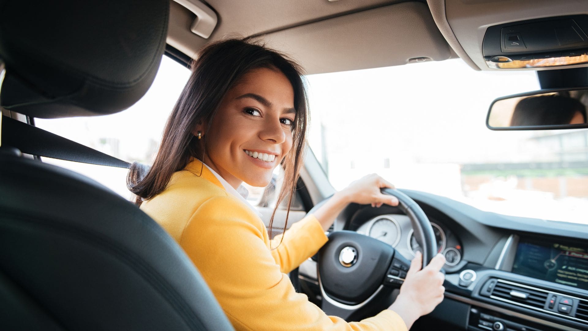 Woman looking back while driving a car