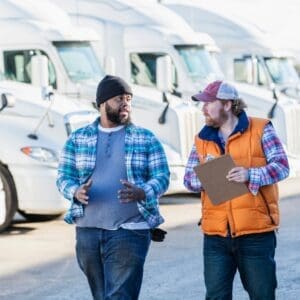 Driver and manager walking past fleet of vehicles