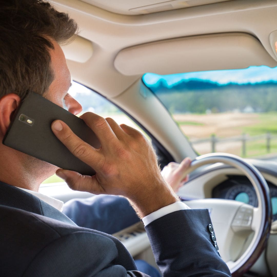 Business man taking a call while driving