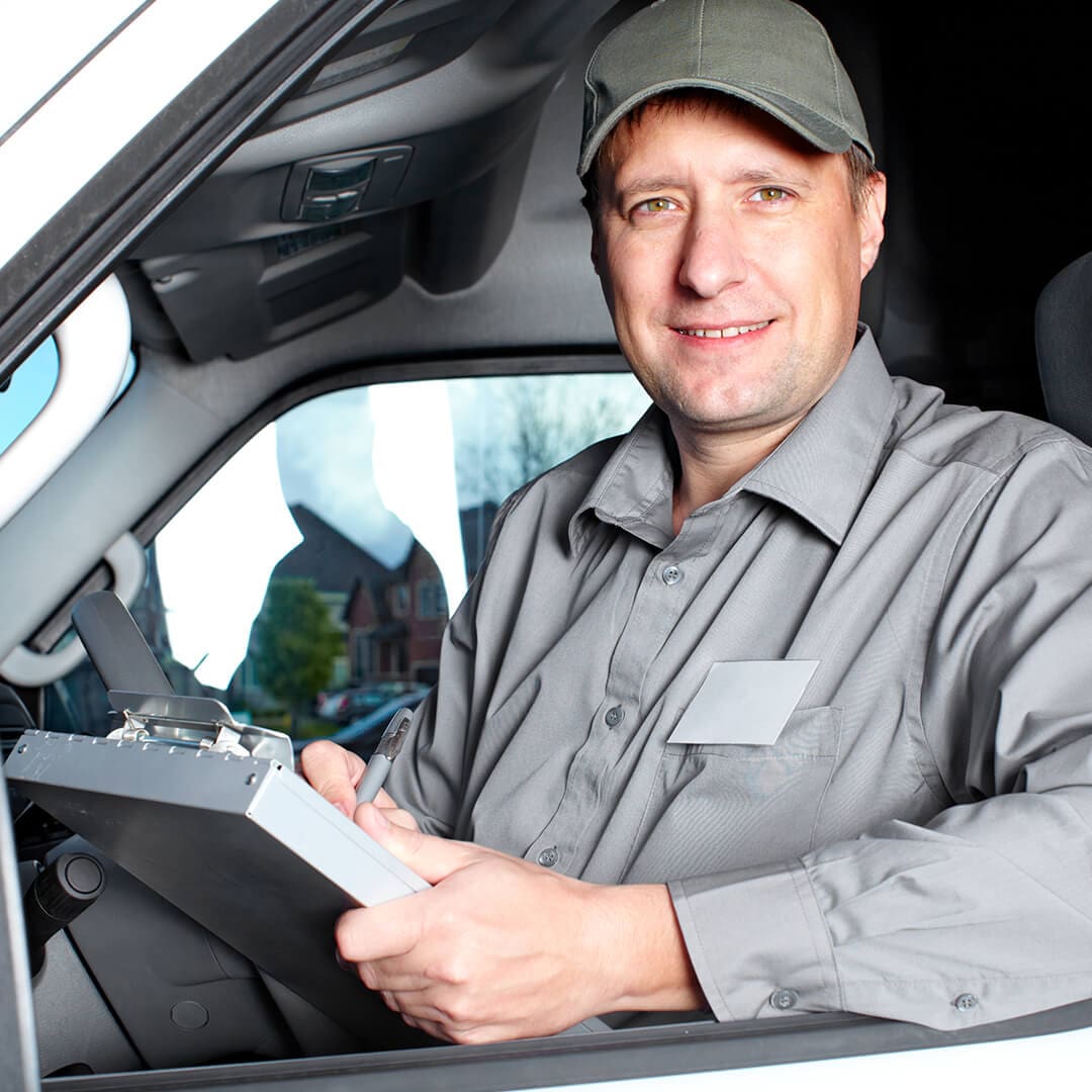 man with a clipboard writing down schedule in his van