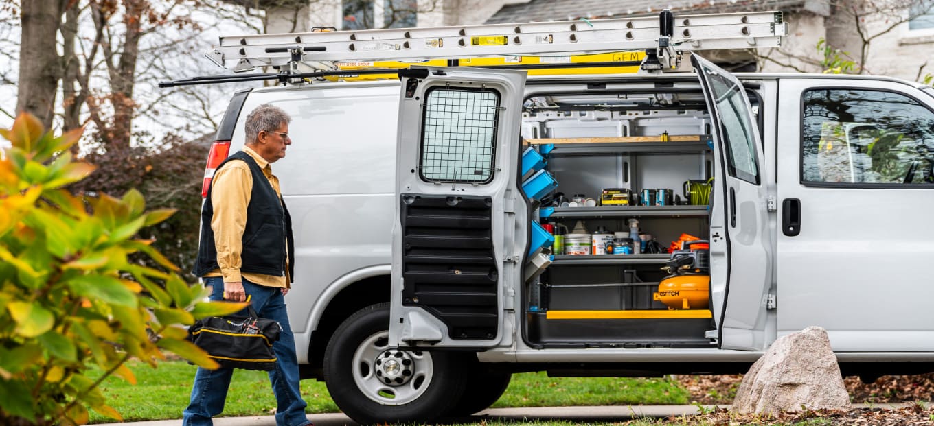 HVAC van for home services upfitted with a man walking toward it with a toolbox