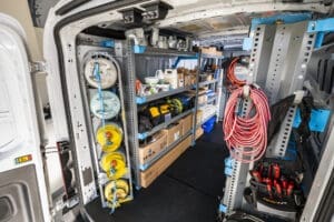 Inside of a van that has been upfitted with shelving, racks to secure tanks, and more for HVAC contractors.