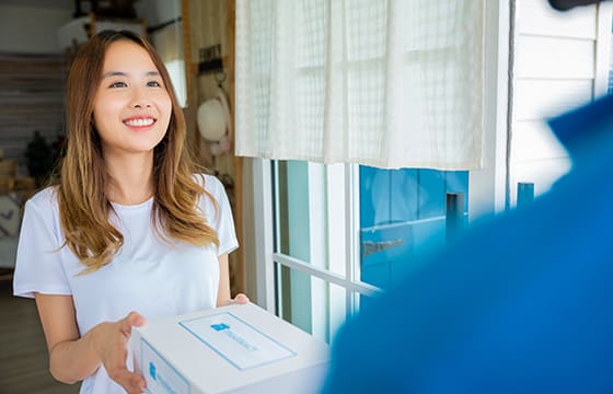 A woman accepting a delivery of perscription medicine to her home