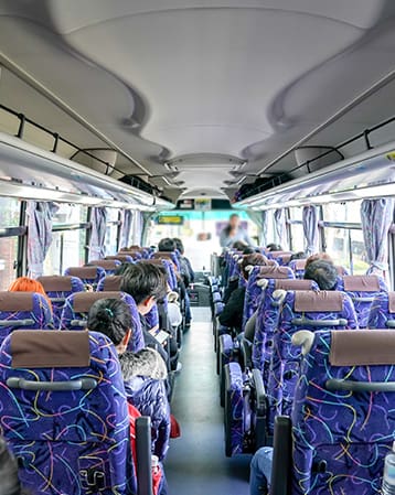 A landscape of a shuttle bus full of people from back to the front