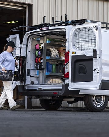A woman walking toward an upfitting HVAC Van from Adrian Steel