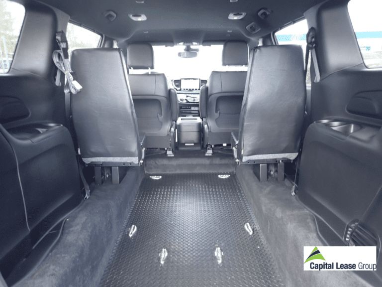 Wheelchair accessible mini van white with wheelchair ramp in rear of the van. Ramp is up and gate is closed. Interior of the van showing the area for the wheelchair. Chrysler Voyageur