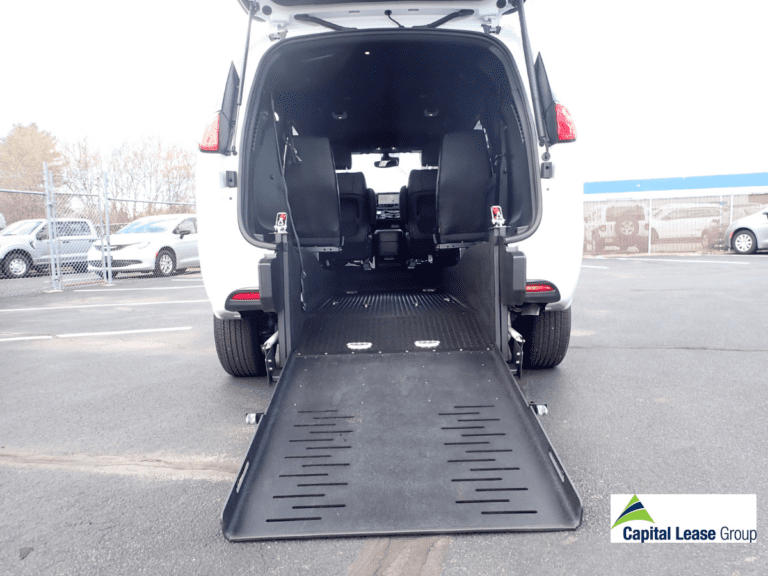 Wheelchair accessible mini van white with wheelchair ramp in rear of the van. Ramp is deployed. Chrysler Voyageur