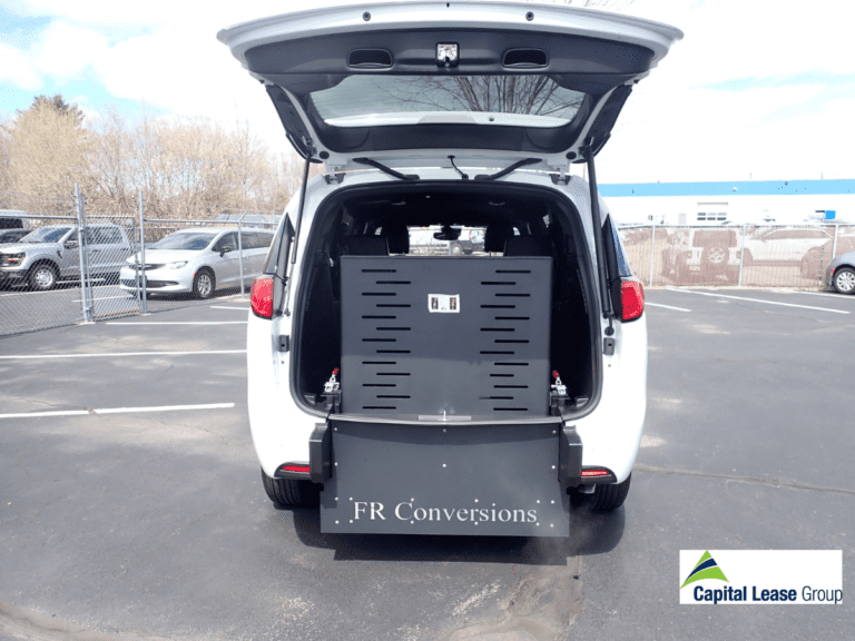 Wheelchair accessible mini van white with wheelchair ramp in rear of the van. Ramp is up. Chrysler Voyageur